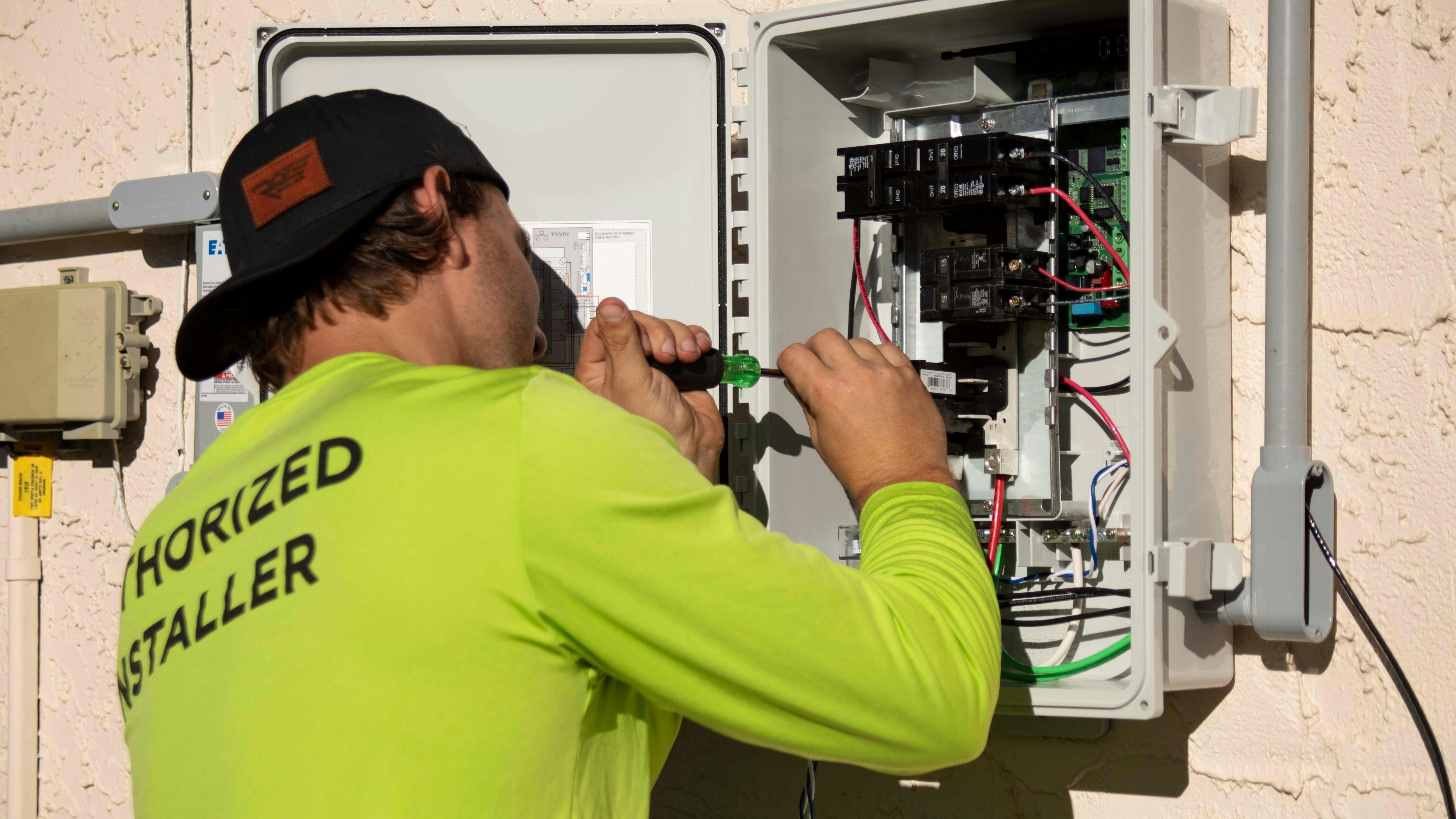 Électricien réalisant une installation sur un tableau électrique